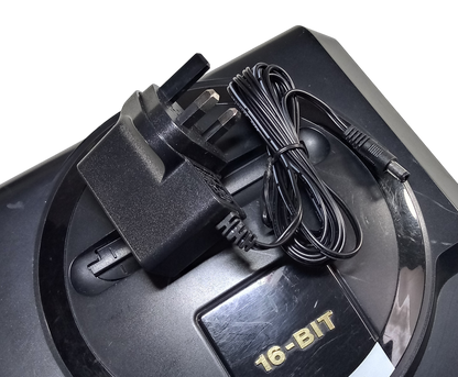 Regulated power supply for Sega Mega Drive / Genesis 1 with UK plug on top of the console